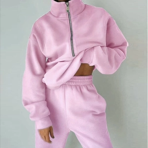 Detalle de chándal de forro polar rosa con sudadera de media cremallera y joggers