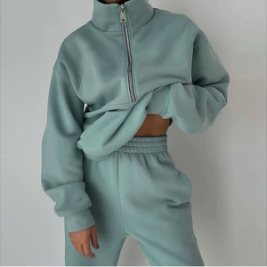 Detail of high-neck half-zip sweatshirt and matching joggers in morandi green fleece