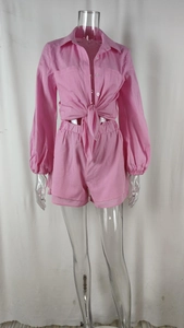 Detail of pink two-piece set featuring tie-front long sleeve shirt and high waist shorts