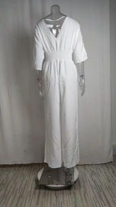 Detail of white wide-leg jumpsuit showing back V-neck and elastic gathered waist design