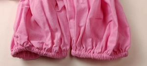 Detailed close-up of pink casual suit showing elastic cuff texture and cotton fabric