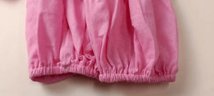 Detailed view of pink fabric texture and elastic cuff with delicate stitching finish
