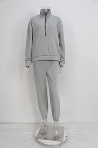 Detail view of grey two-piece tracksuit set with half-zip sweatshirt and jogger pants