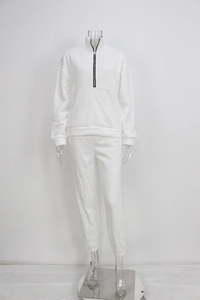 Detalle de conjunto deportivo blanco de dos piezas con sudadera de cremallera y jogger