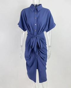 Détail d'une robe chemise bleu marine avec lien à la taille, plis et boutonnière sur le devant