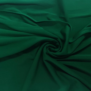 Detailed texture of dark green flowing textile fabric with elegant drapes and soft folds