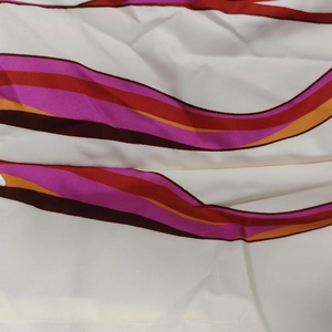 Detailed view of colorful curved stripe pattern on smooth textured ivory fabric