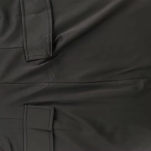 Close-up of black bodycon dress fabric showing refined seam and pocket detail textures