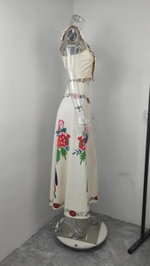 Detail of floral embroidery and ruffled hem on a two-piece cream skirt set for women