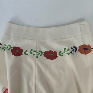 Detailed macro view of the cream-colored skirt waist featuring colorful floral prints