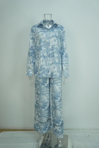 Detail of blue Toile de Jouy print on white long-sleeve pajama set with black trim piping