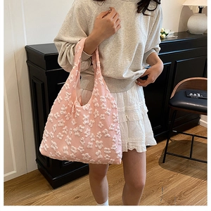 Detail of pink floral tote bag with 3D embossed lace texture and wide shoulder strap