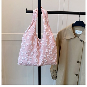 Detail of pink floral tote bag featuring 3D white blossoms on soft fabric textures