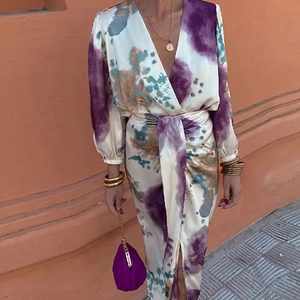 Detailed close-up of V-neck wrap top with purple abstract print and tie-waist detail