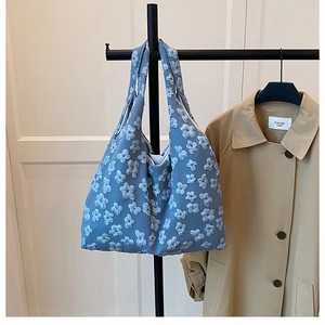 Detailed macro view of 3D floral texture on morandi blue tote bag in a home setting