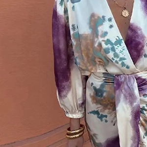 Detailed view of abstract print dress with V-neckline and puff sleeve wrist cuffs