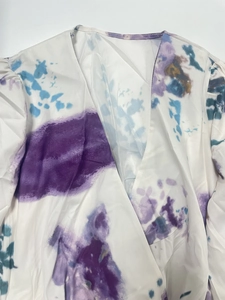Detail of cross V-neckline on white blouse with purple and teal watercolor dye print