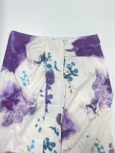 Detail of white high-waist maxi skirt with blue and purple artistic tie-dye pattern