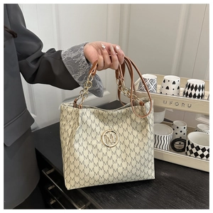 Detail of off-white tote bag with M-pattern print and gold chain leather strap