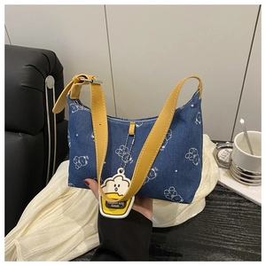 Détail du sac sous le bras en denim avec motifs d'ours blancs et bandoulière jaune