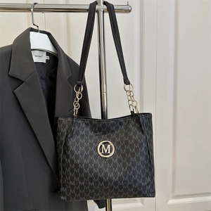 Classic black tote bag with gold chain accents and all-over M pattern print