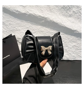 Détail du sac nuage plissé noir avec boucle nœud en métal doré et large bandoulière