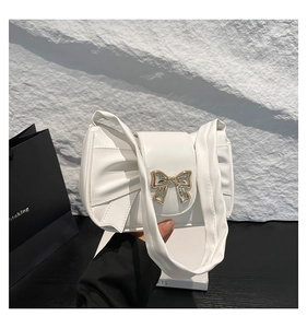 Détail du sac blanc en PU montrant le fermoir doré et la texture du cuir plissé