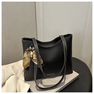 Détail d'un sac cabas noir avec surpiqûres blanches contrastées et foulard en soie
