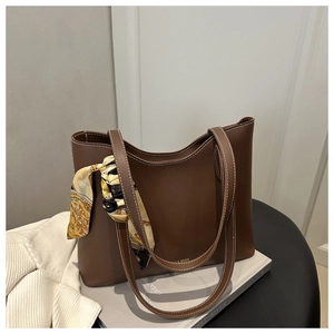 Détail du cabas marron avec surpiqûres blanches et foulard en soie décoratif sur l'anse