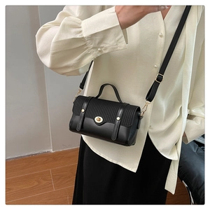 Detail van crossbodytas met geweven flap en gouden draaisluiting voor vrouwen