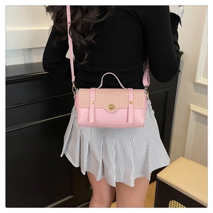 Detail van de roze lederen en geweven stro crossbodytas gedragen door een model voor maat