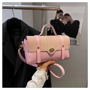 Detail van roze kunstleren handtas met beige geweven klep en goudkleurig draaislot