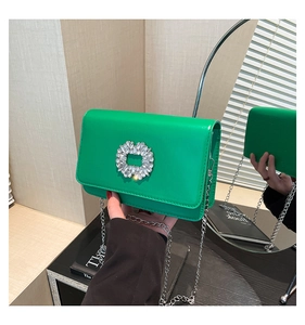 Detail of a bright green crossbody bag featuring a shimmering rectangular crystal buckle