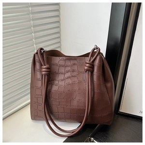 Dettaglio borsa tote marrone con stampa coccodrillo e tracolla con nodi decorativi
