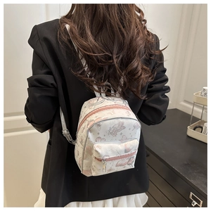 Mini butterfly print backpack for women featuring greyish-white fabric and pink zippers