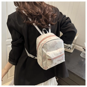 Close-up of a mini butterfly print backpack on model showing size and faux leather texture