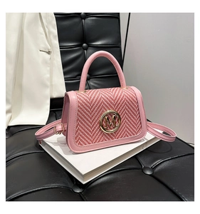 Dettaglio borsa a tracolla rosa con patta intrecciata rossa e bianca e logo M dorato