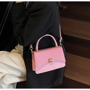 Détail du rabat tissé rose et de la boucle dorée d'un sac à main carré élégant
