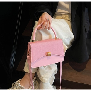 Détails d'un sac à main rose en cuir avec boucle dorée et tenue décontractée chic