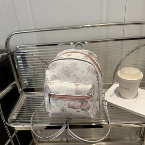 Mini-Rucksack in Creme mit rosa Schmetterlingsdrucken und Sternen auf Metallregal