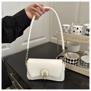 Detalle del bolso de hombro blanco roto con hebilla dorada y asa de cadena metálica