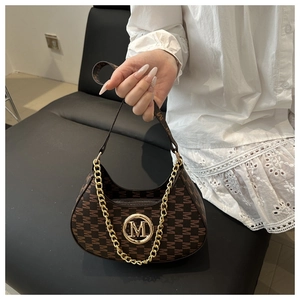 Detail of coffee-colored shoulder bag with gold M-logo and chunky chain strap