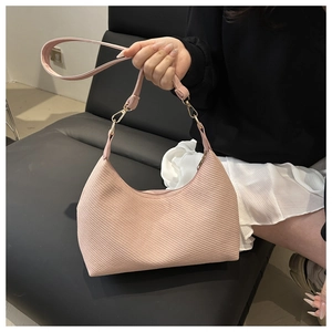 Detail of light pink hobo bag featuring woven texture and adjustable leather straps