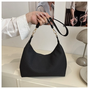 Detailed view of black crescent tote bag featuring twill texture and gold metal buckle