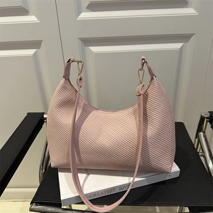 Minimalist light pink crescent tote bag with textured finish and gold metal buckle