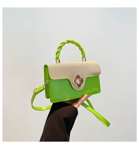 Detail of neon green leather and woven mini bag with twist handle and gold flower clasp