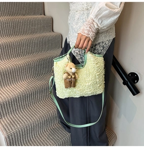 Detail of pleated bubble texture handbag with mint green strap and cute bear charm
