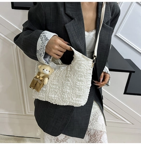 Detailed texture of white bubble fabric shoulder bag with a cute bear charm accessory