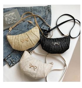 Detailed view of woven dumpling bags with gold bow accents and adjustable straps