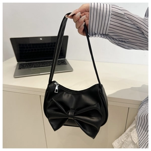 Détail du sac à main en cuir PU noir avec un grand nœud décoratif et zip argenté